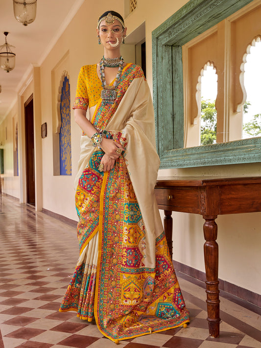 Woman wearing beige silk blend saree with traditional indian motif work and mustard blouse