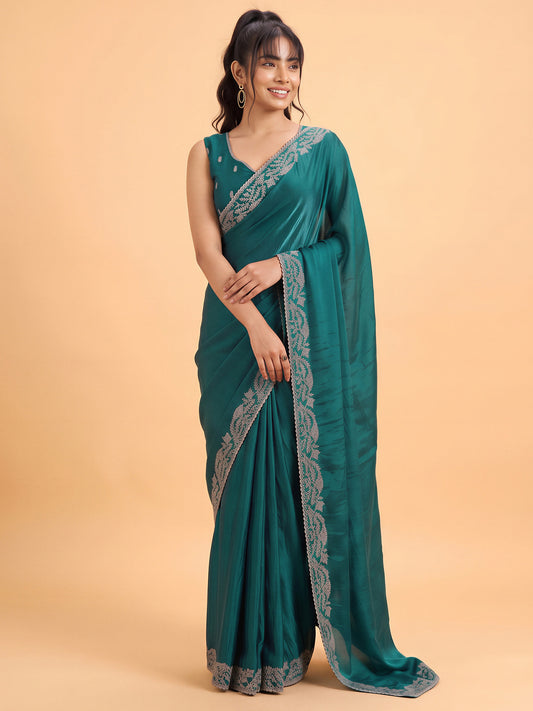Woman wearing teal green satin silk saree with clean solid-tone finish and teal green blouse