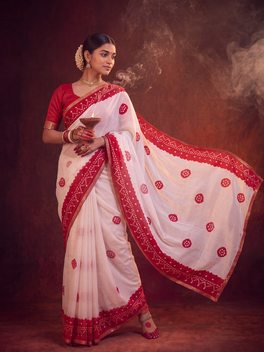 Woman wearing white georgette saree with bandhani tie-dye dot work and red blouse