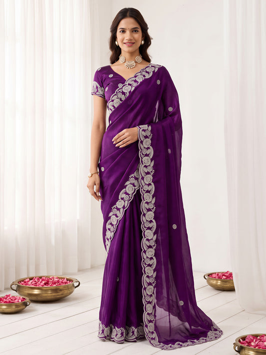 Woman wearing purple satin saree with embroidered motif work and purple blouse