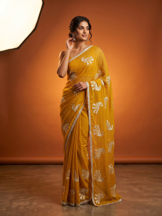 Woman wearing mustard georgette saree with embroidered motif work and mustard blouse