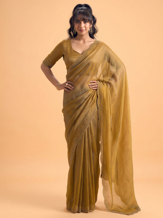 Woman wearing gold satin silk saree with ornamented surface design and gold blouse