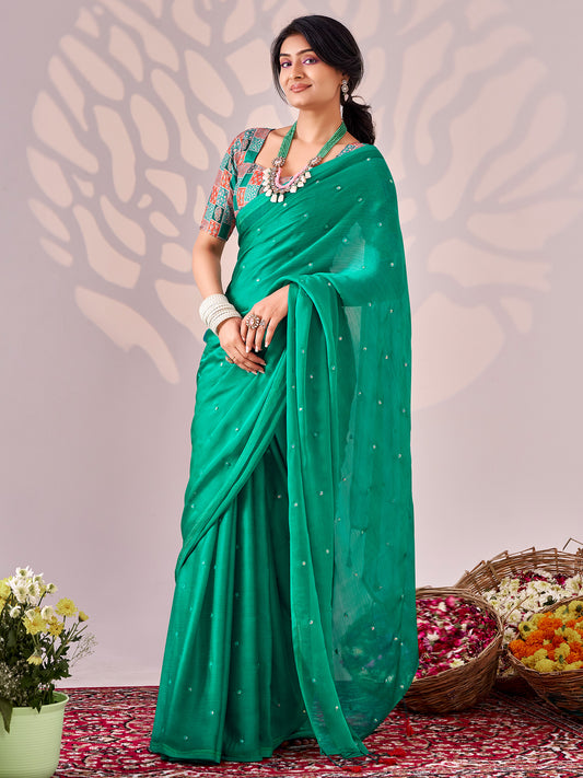 Woman wearing teal green chiffon saree with ornamented surface design and multicolored blouse