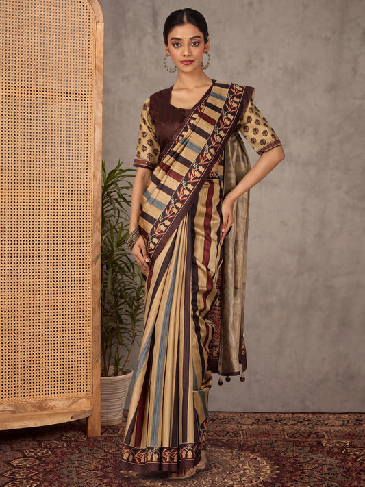 Woman wearing beige silk blend saree with striped pattern design and brown blouse