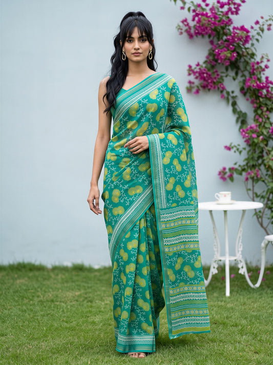 Woman wearing teal green crepe saree with botanical floral and leaf design and teal green blouse