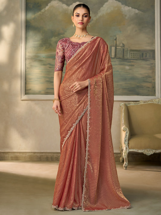 Woman wearing rust georgette saree with embroidered motif work and mauve blouse