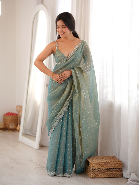 Woman wearing light blue silk blend saree with ornamented surface design and light blue blouse