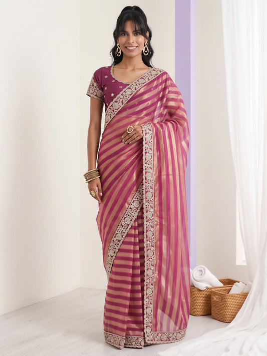Woman wearing purple net saree with embroidered motif work and purple blouse