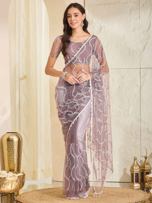 Woman wearing mauve net saree with ornamented surface design and mauve blouse
