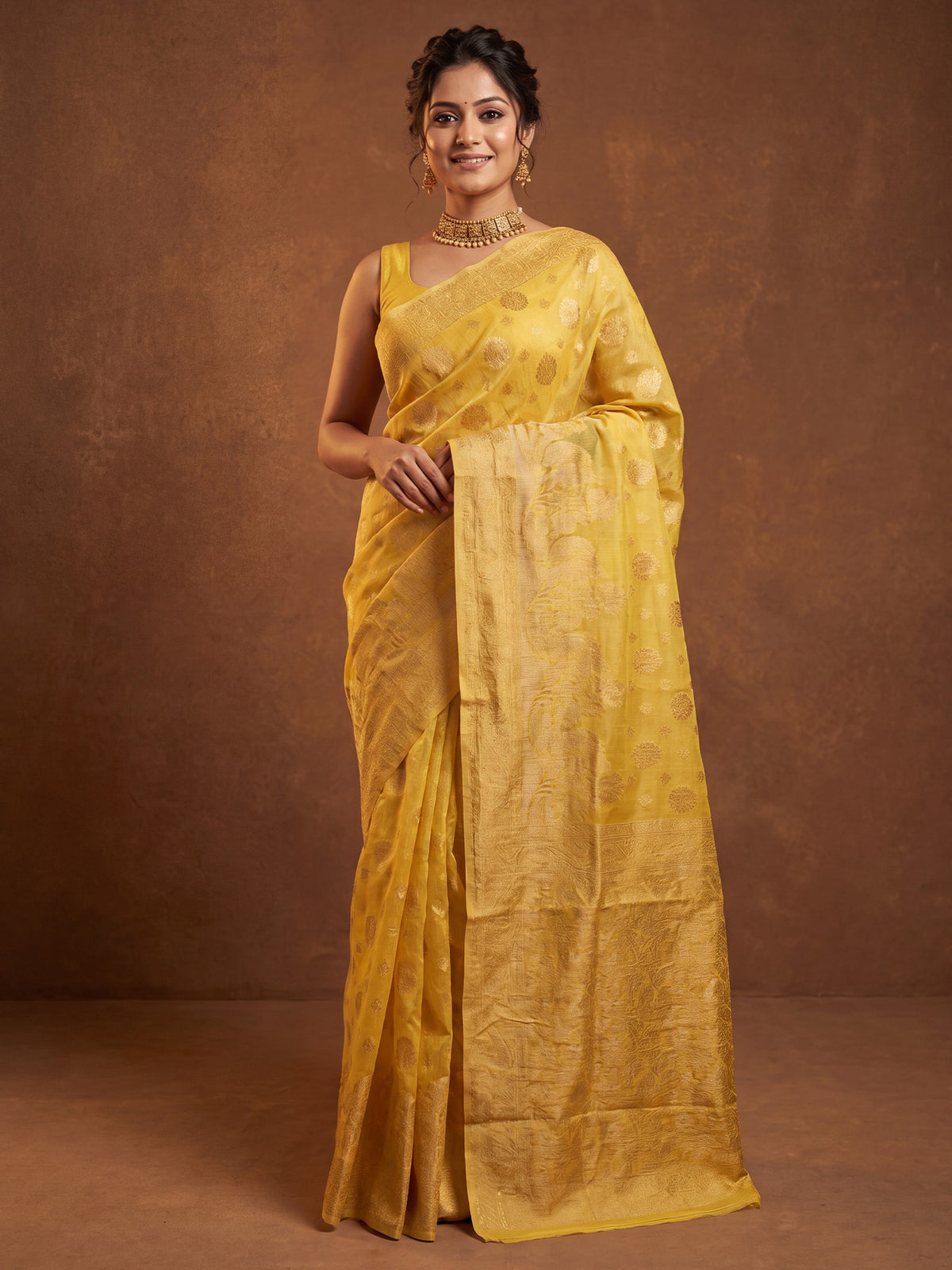 Woman wearing yellow silk blend saree with zari butta (metallic motif) work and yellow blouse