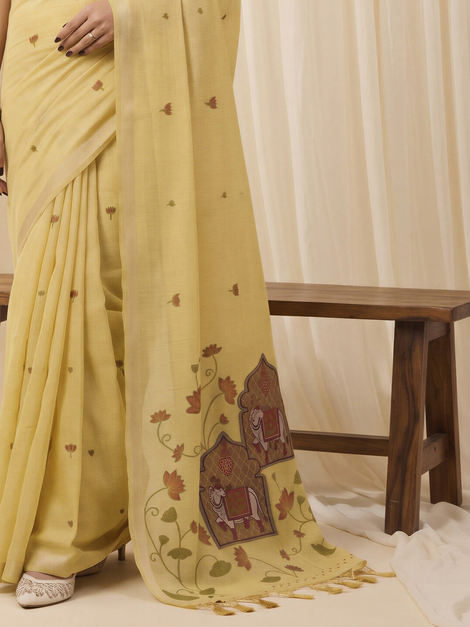 Pallu detail of yellow pure cotton saree showing traditional indian motif work and solid border