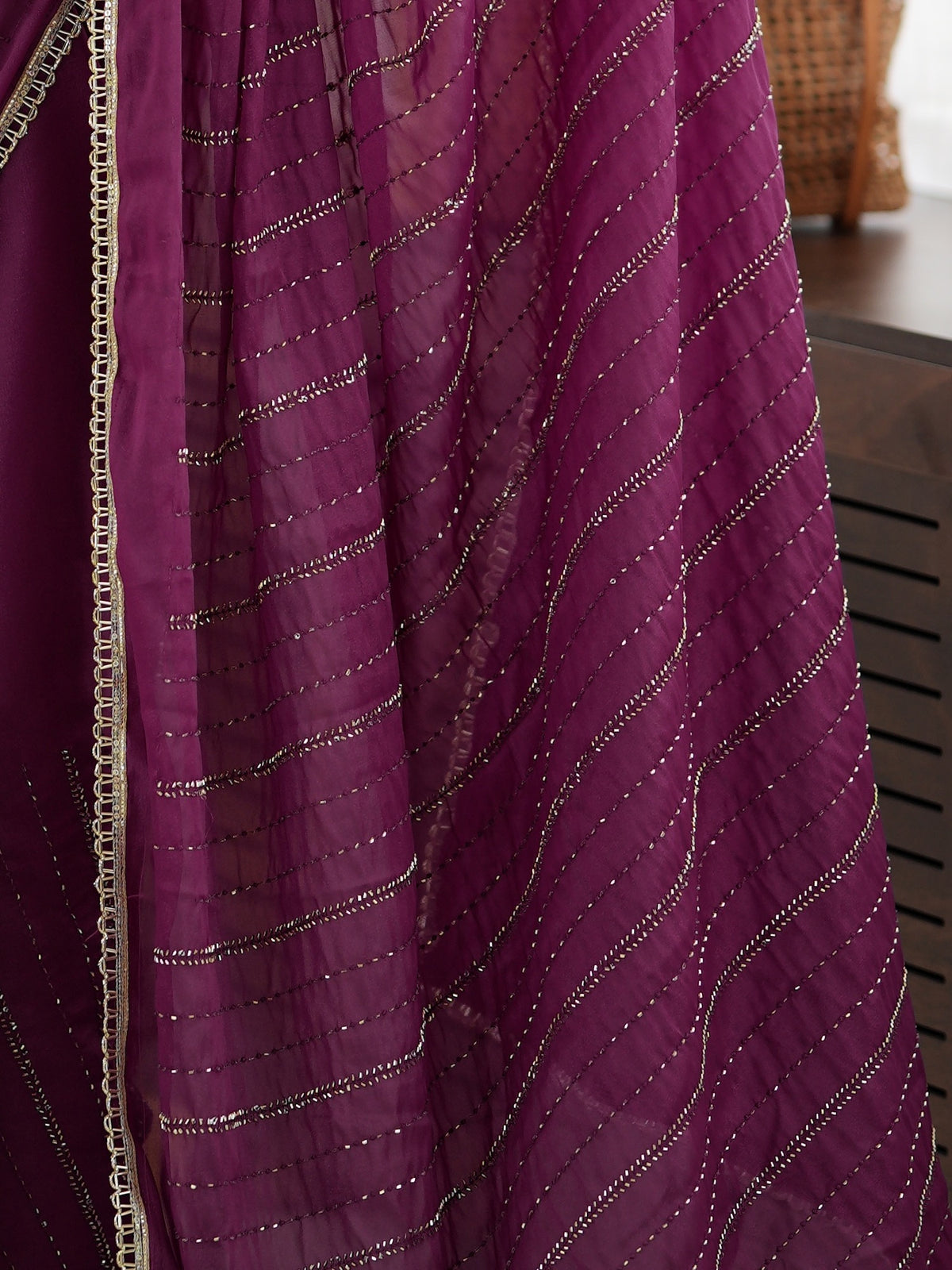 Pallu detail of purple georgette saree showing ornamented surface design and embellished border