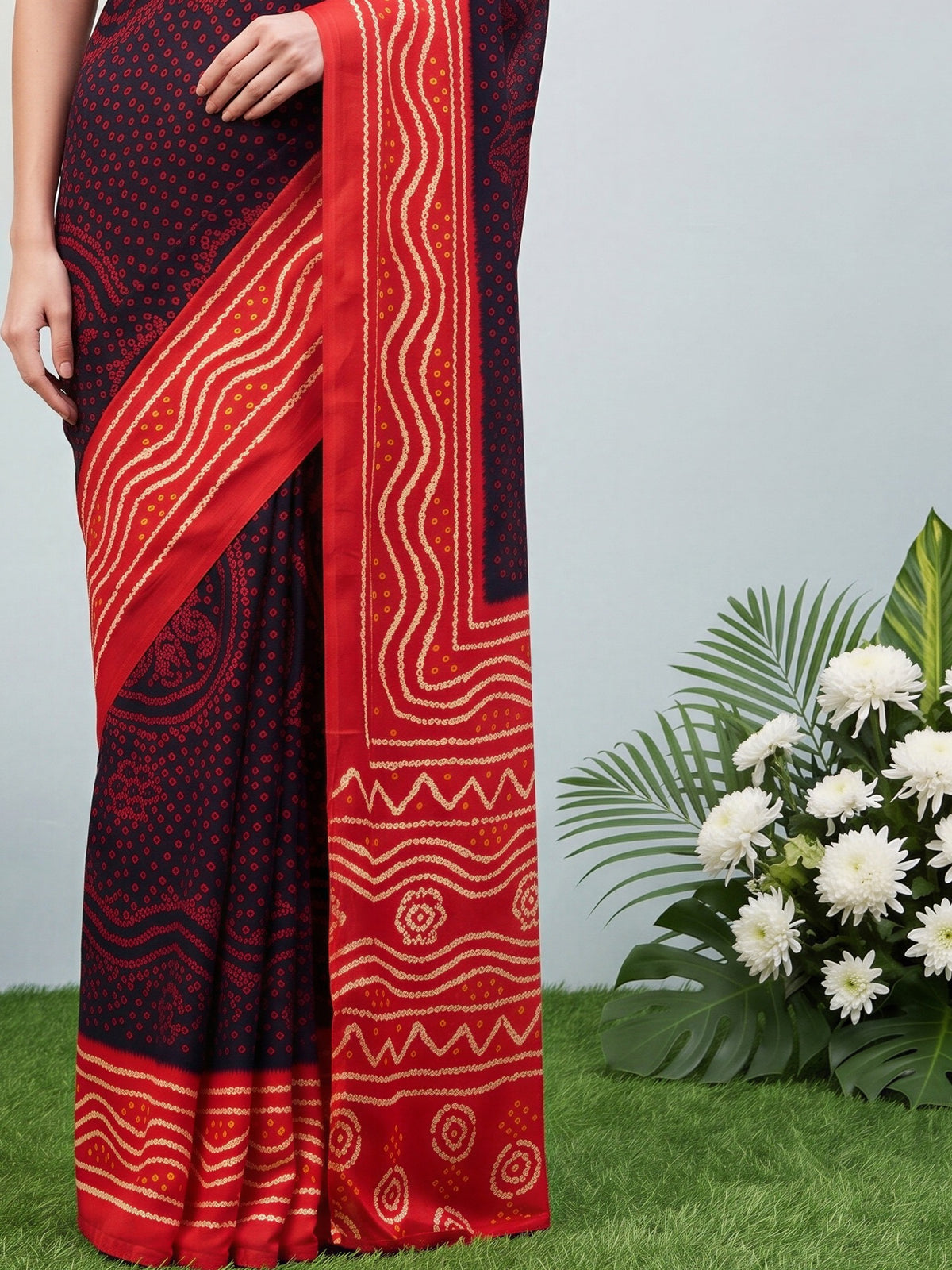 Pallu detail of black satin silk saree showing bandhani tie-dye dot work and printed border