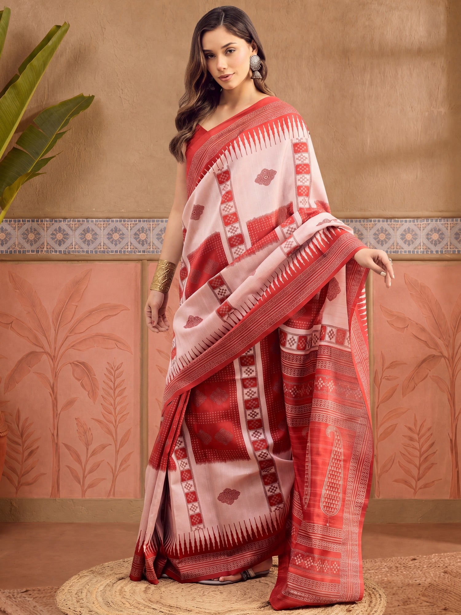Woman wearing beige bhagalpuri silk saree with ikat resist-dyed pattern and red blouse