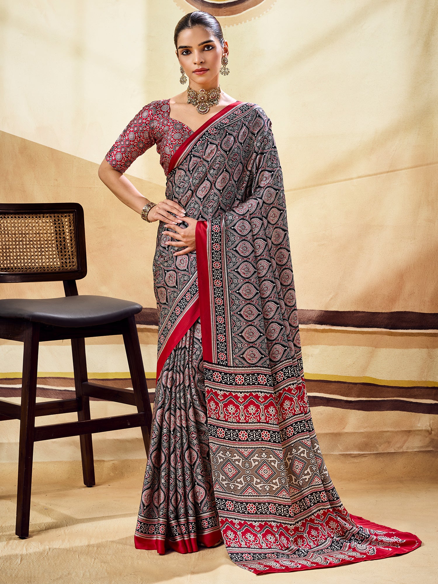 Woman wearing black satin saree with ajrak block-print motif work and maroon blouse