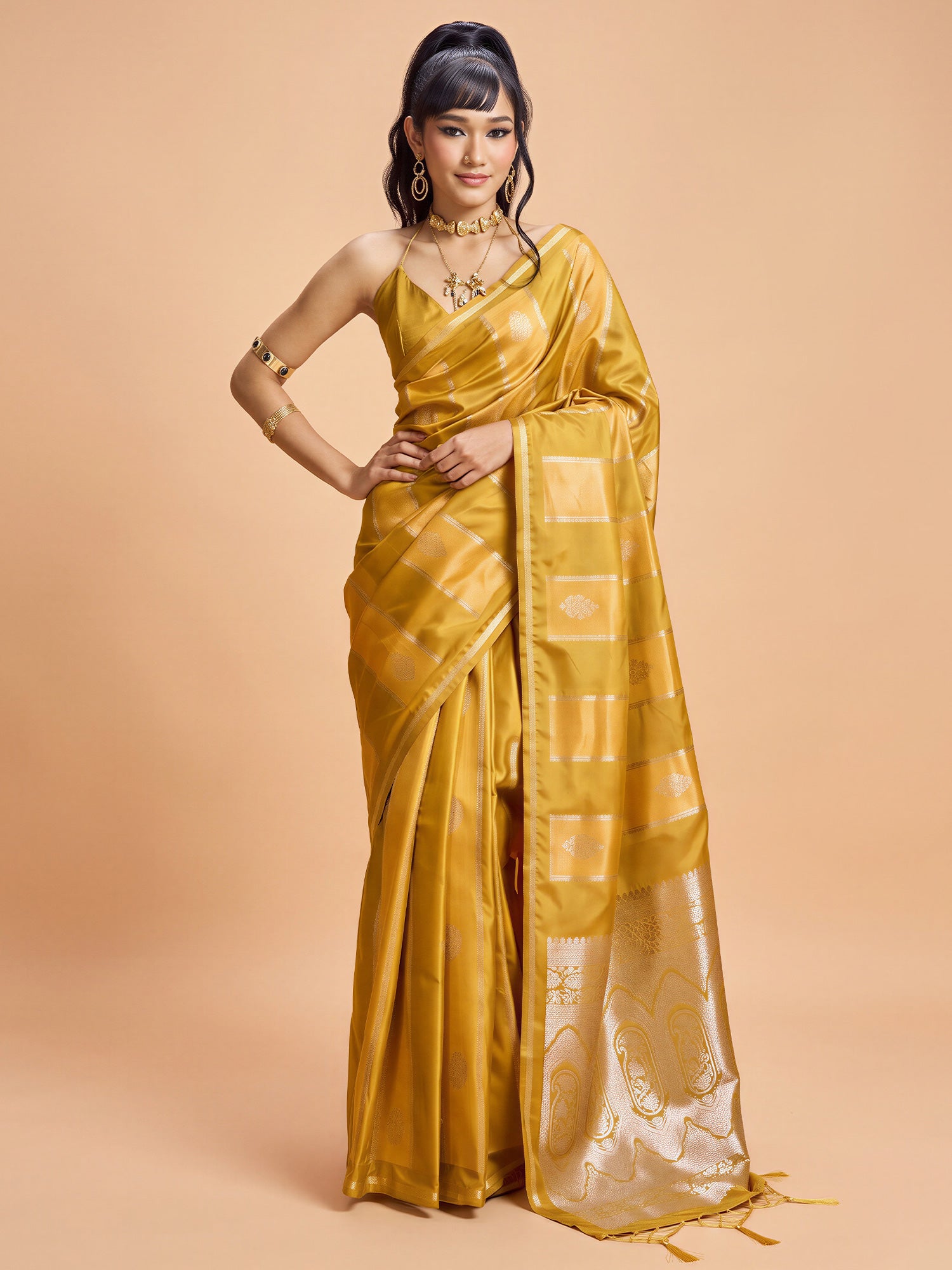 Woman wearing mustard satin saree with traditional indian motif work and mustard blouse