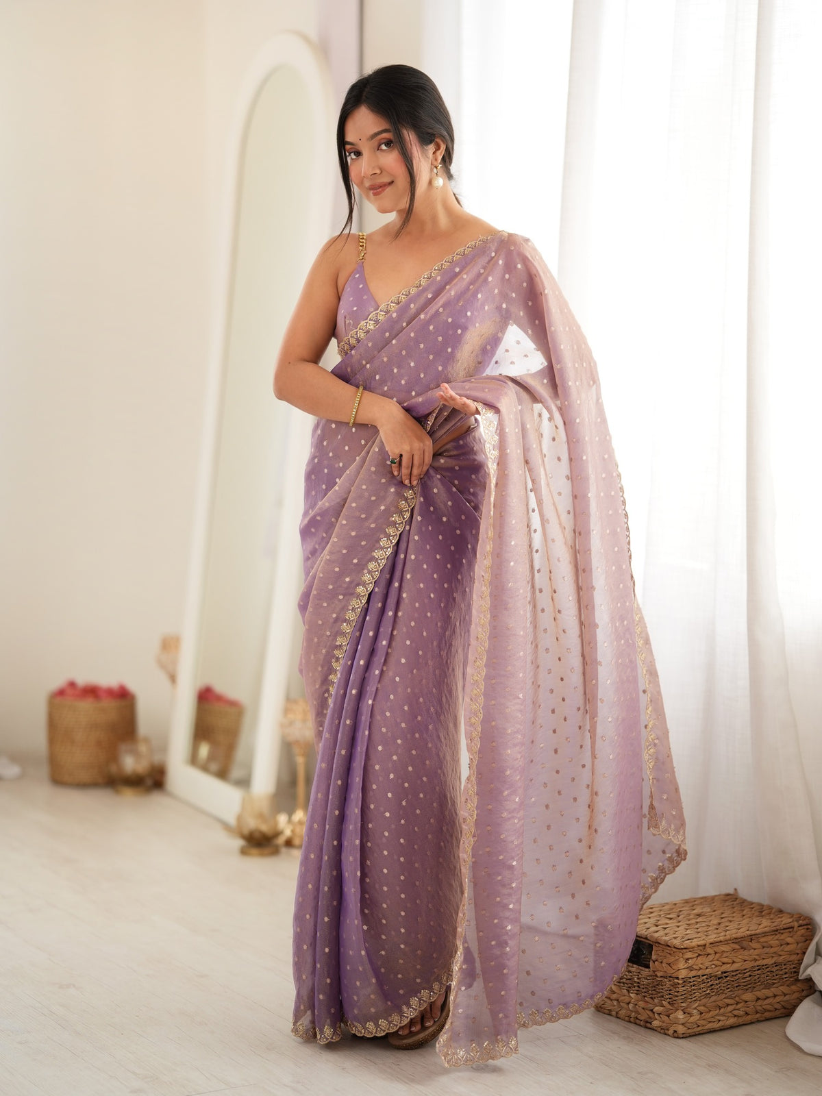 Woman wearing lavender georgette saree with zari butta (metallic motif) work and lavender blouse