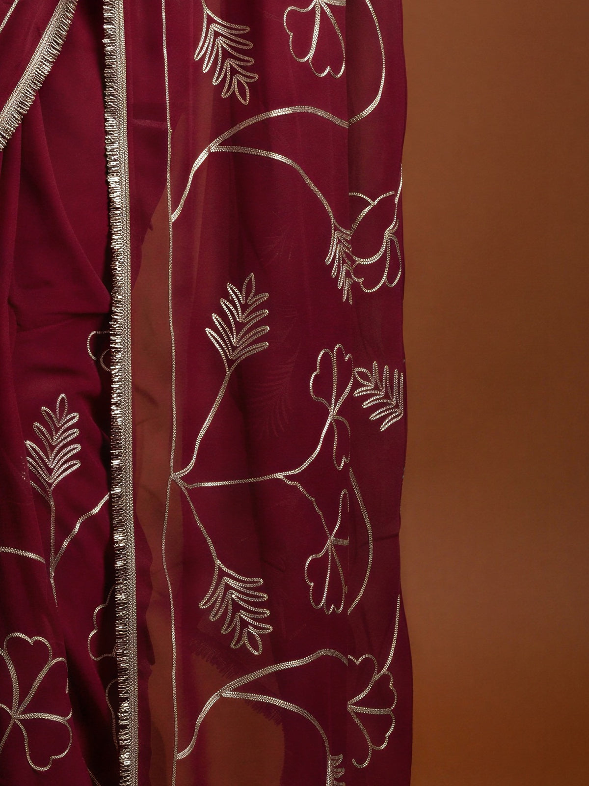 Pallu detail of pink georgette saree showing embroidered motif work and embellished border