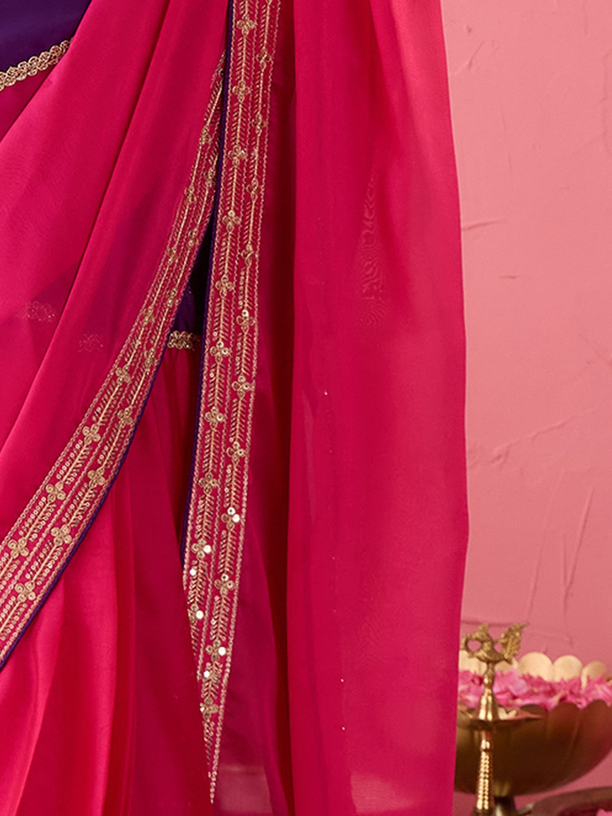 Pallu detail of pink pure georgette saree showing ornamented surface design and embellished border