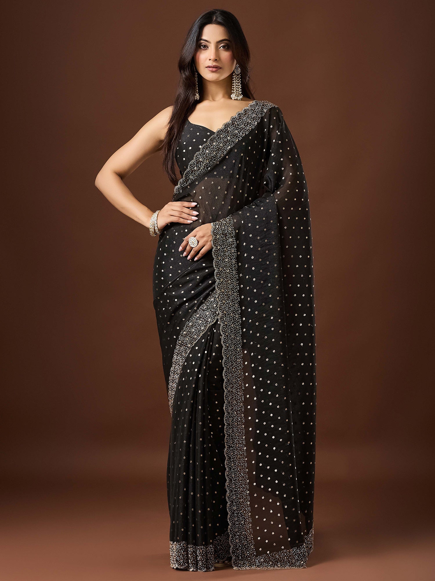 Woman wearing black silk blend saree with ornamented surface design and black blouse