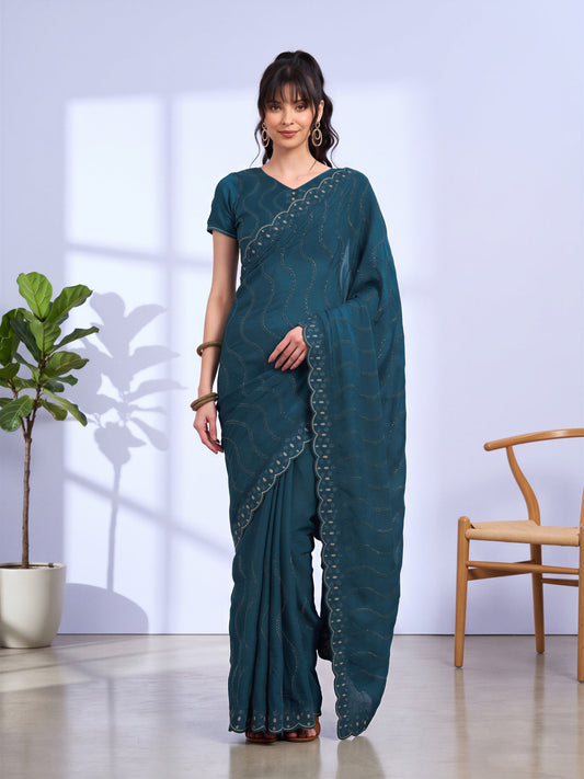 Woman wearing teal blue tissue saree with geometric pattern design and teal blue blouse