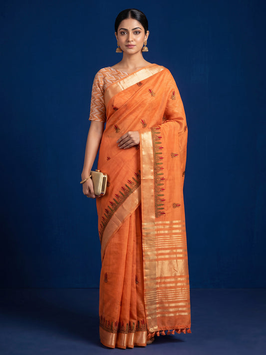 Woman wearing orange cotton linen saree with embroidered motif work and orange blouse