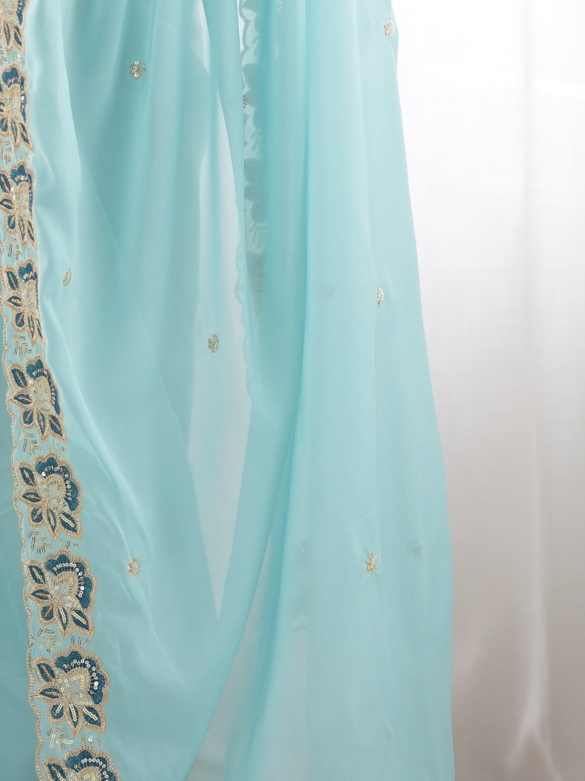 Pallu detail of light blue georgette saree showing ornamented surface design and embellished border
