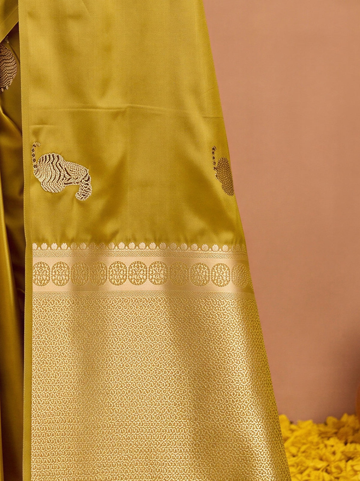 Pallu detail of mustard satin silk saree showing animal-print design and no border border