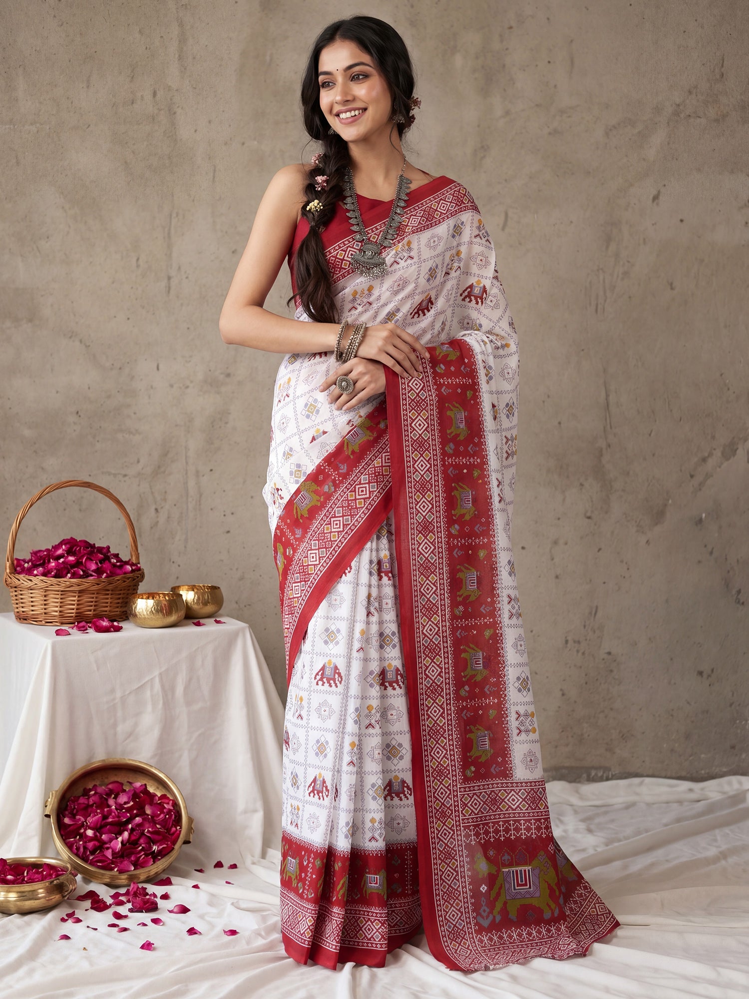 Woman wearing white cotton saree with traditional indian motif work and red blouse