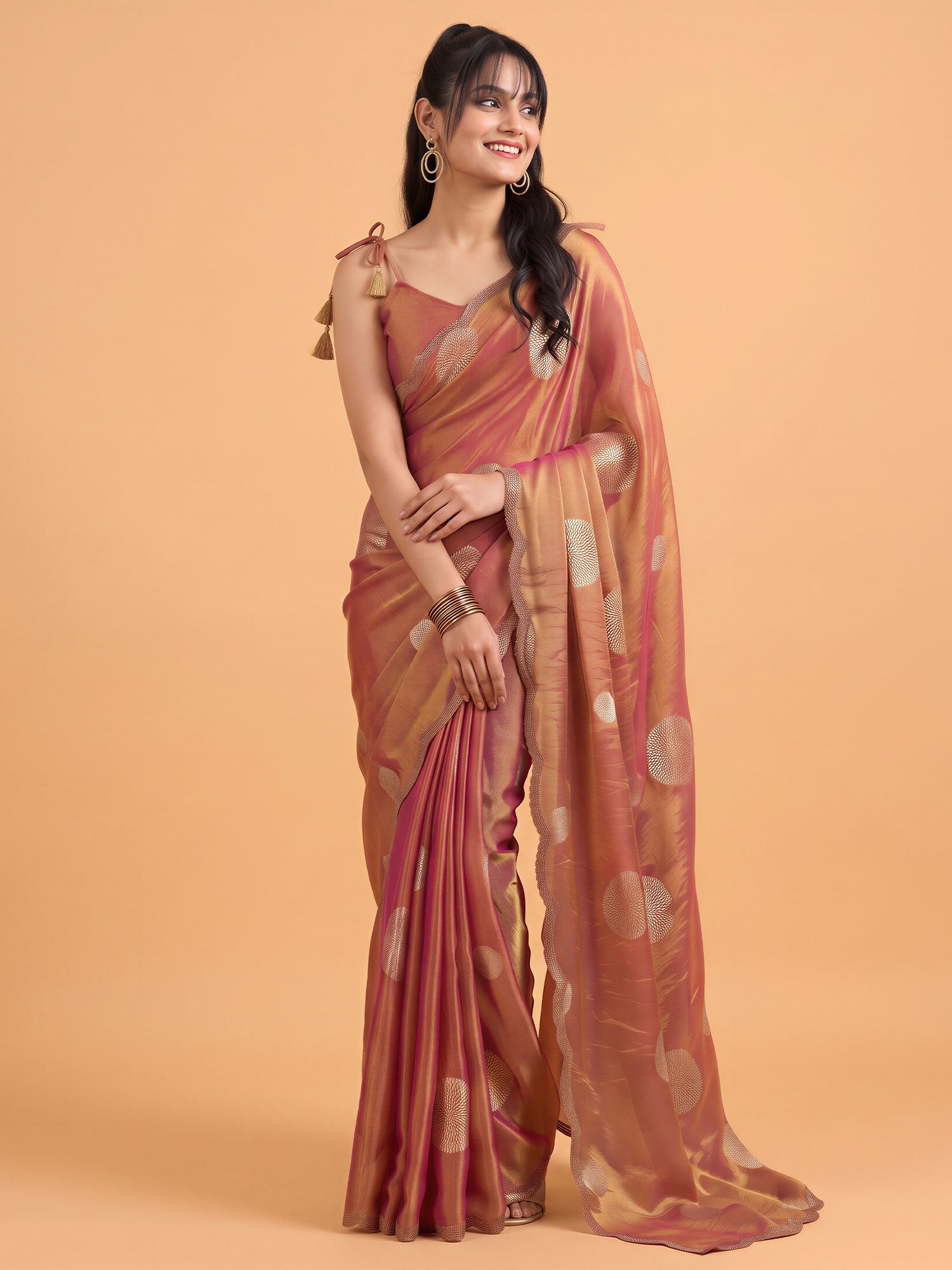 Woman wearing rust satin silk saree with metallic foil print work and rust blouse