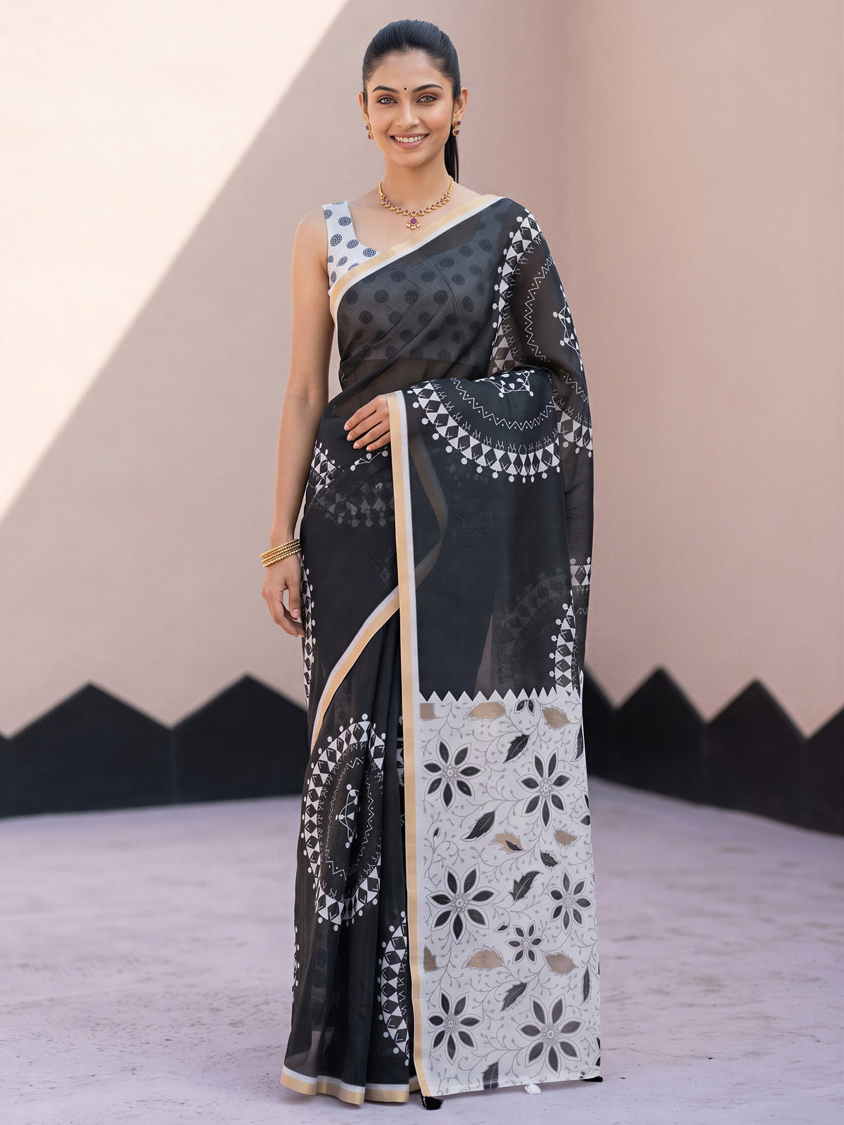 Woman wearing black cotton blend saree with warli folk-art figures and white blouse