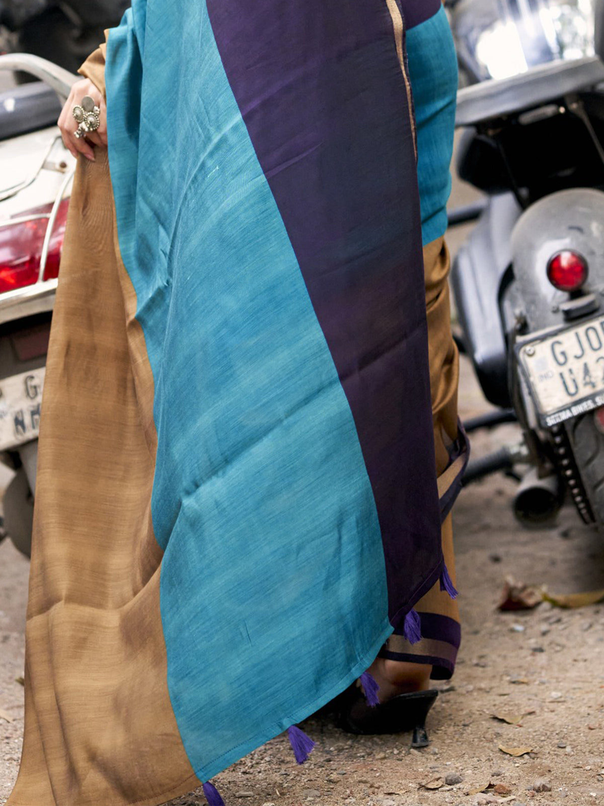 Pallu detail of teal blue cotton blend saree showing colorblocked design and zari border