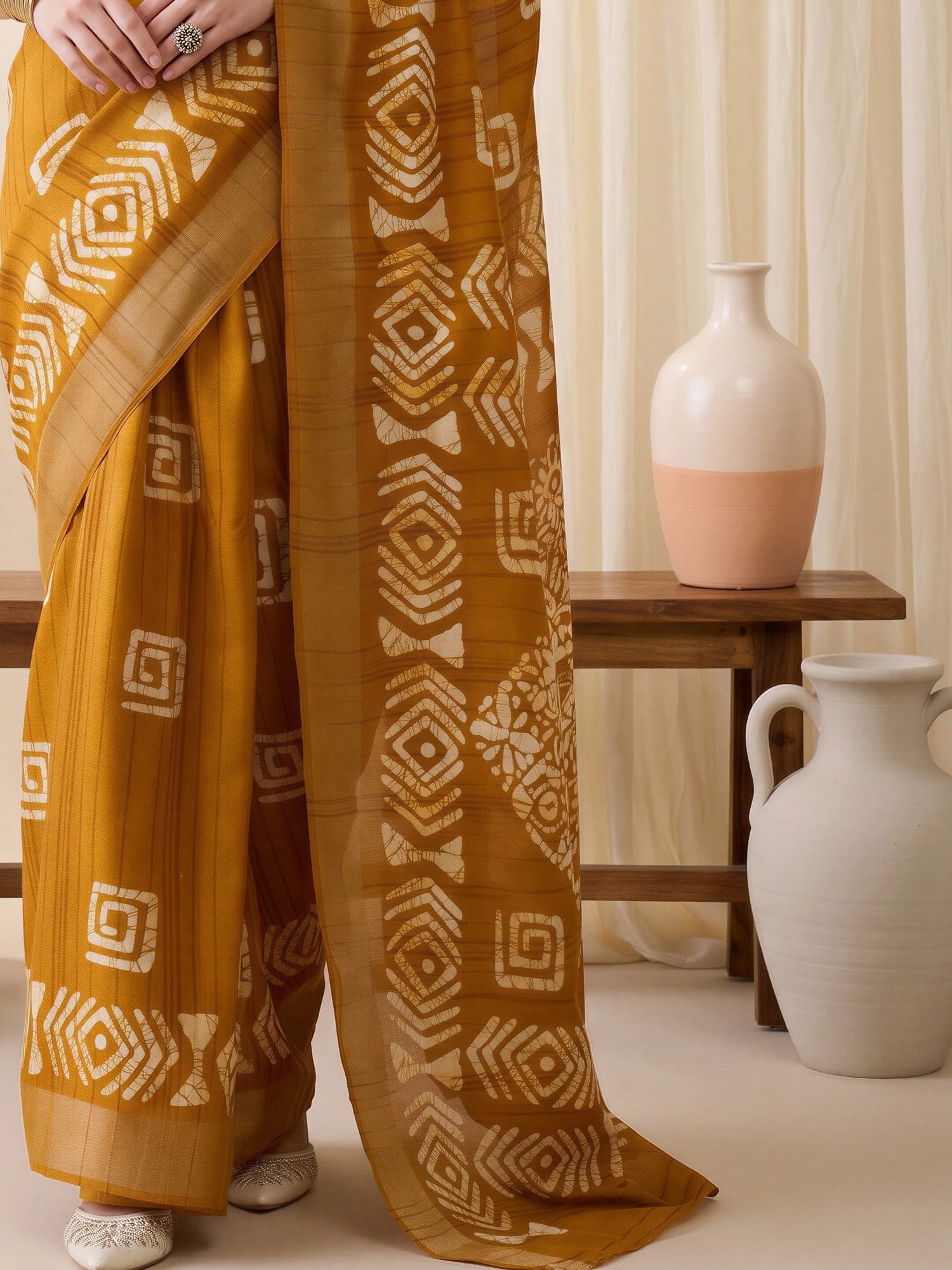 Pallu detail of mustard silk blend saree showing traditional indian motif work and zari border