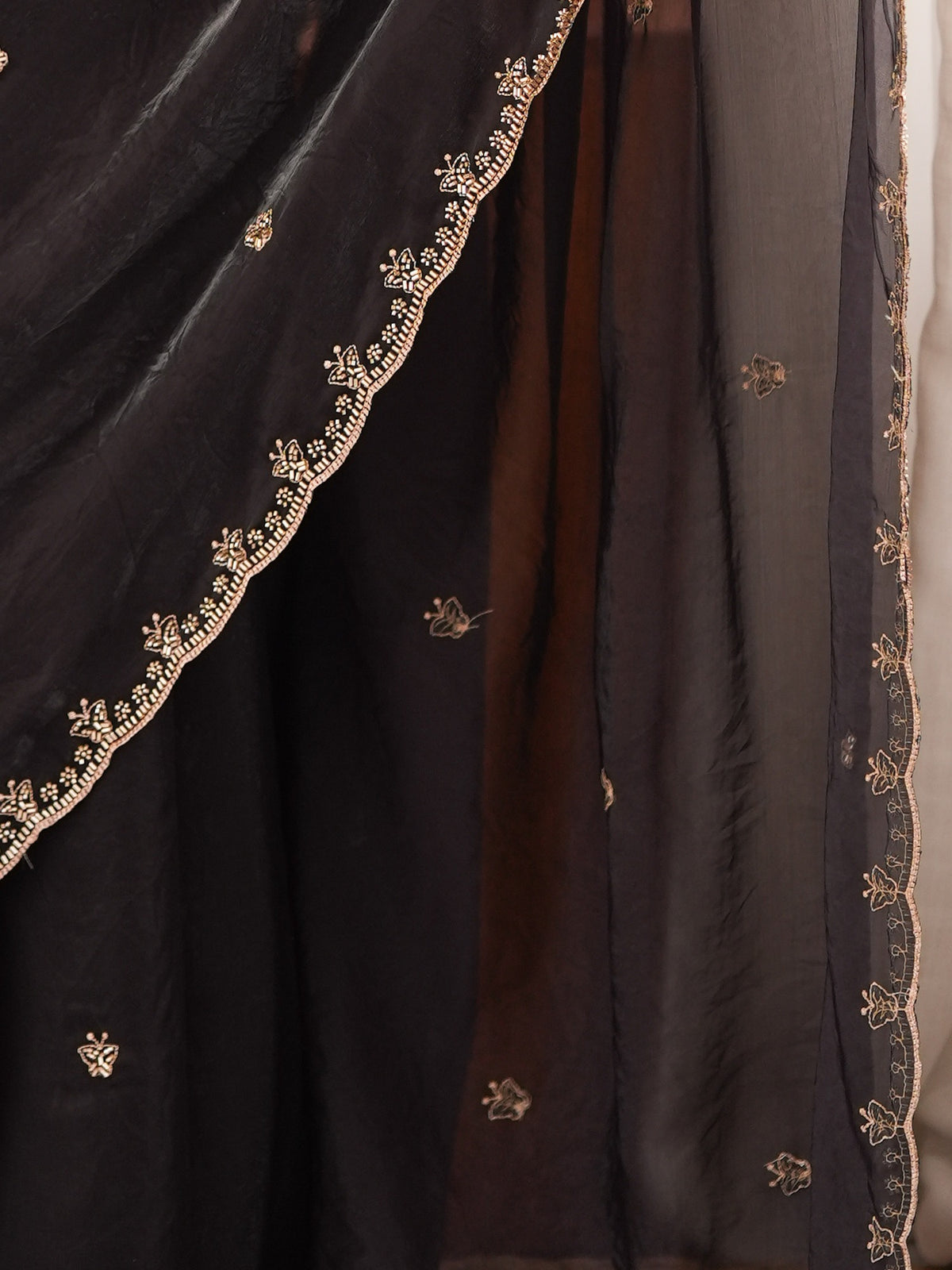 Pallu detail of black satin saree showing ornamented surface design and embellished border
