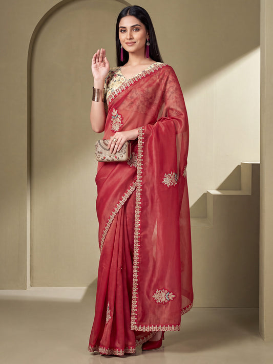 Woman wearing rust tissue saree with ornamented surface design and light green blouse