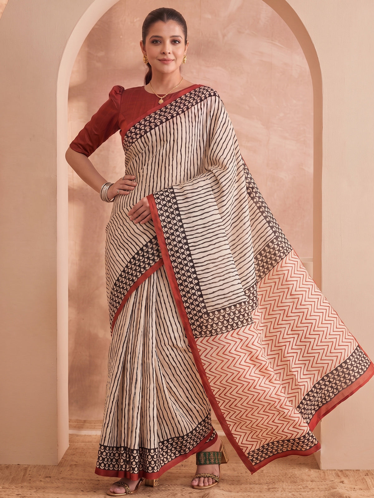 Woman wearing off white bhagalpuri silk saree with striped pattern design and brown blouse