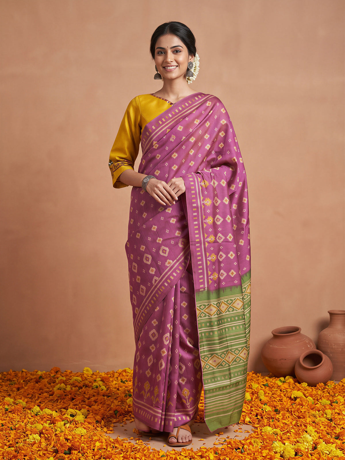 Woman wearing magenta silk blend saree with ikat resist-dyed pattern and mustard blouse
