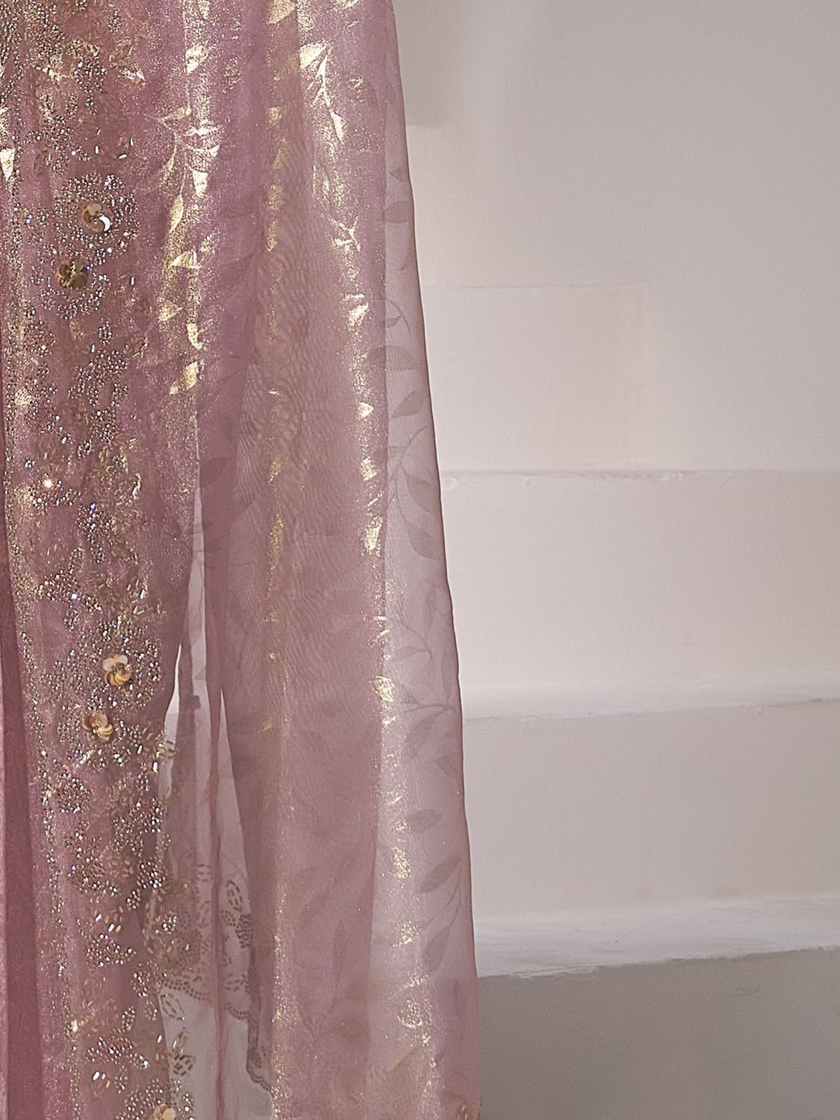 Pallu detail of mauve organza saree showing applique design and scallop border