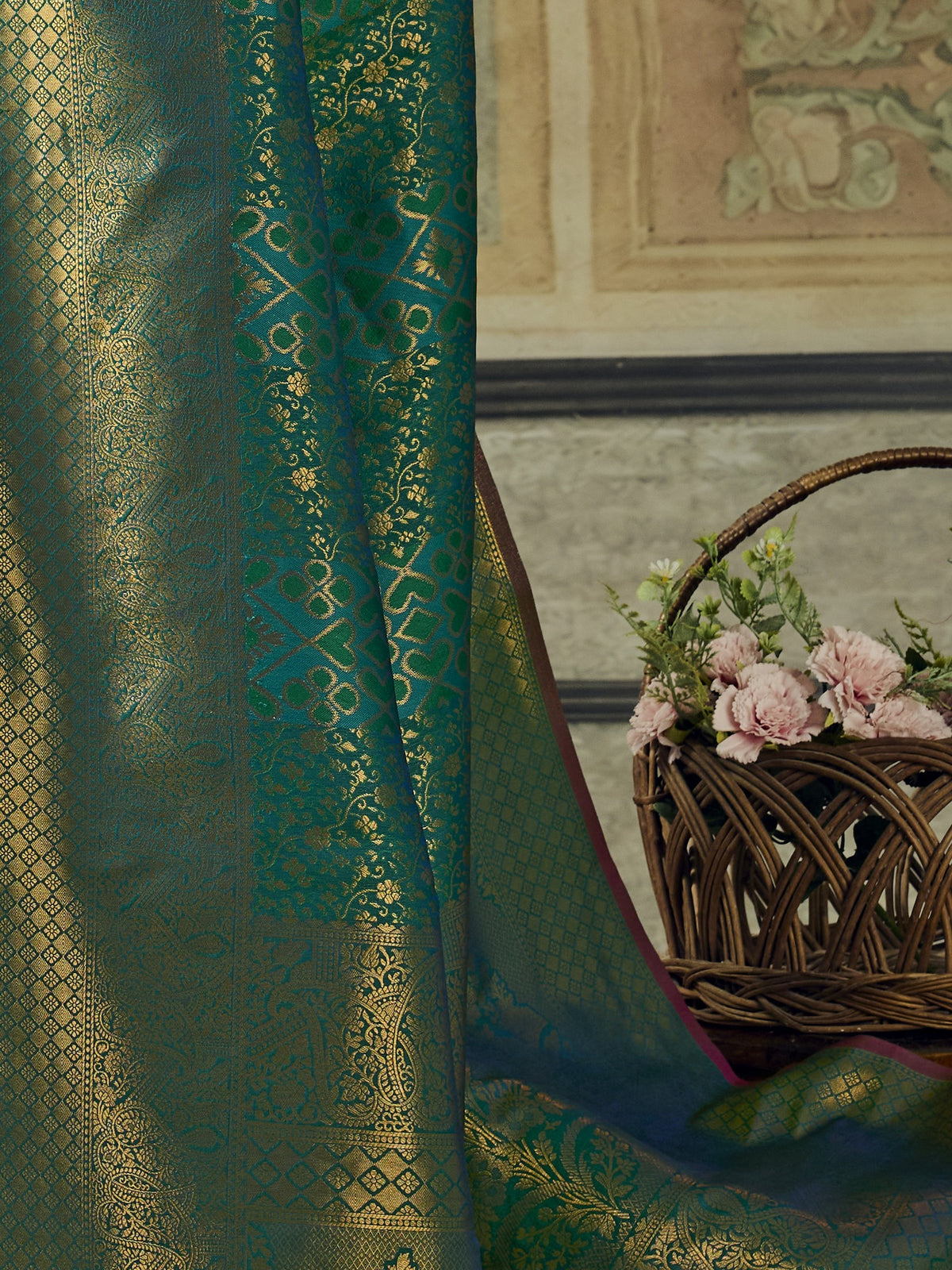 Pallu detail of teal blue pure silk saree showing woven motif design and zari border