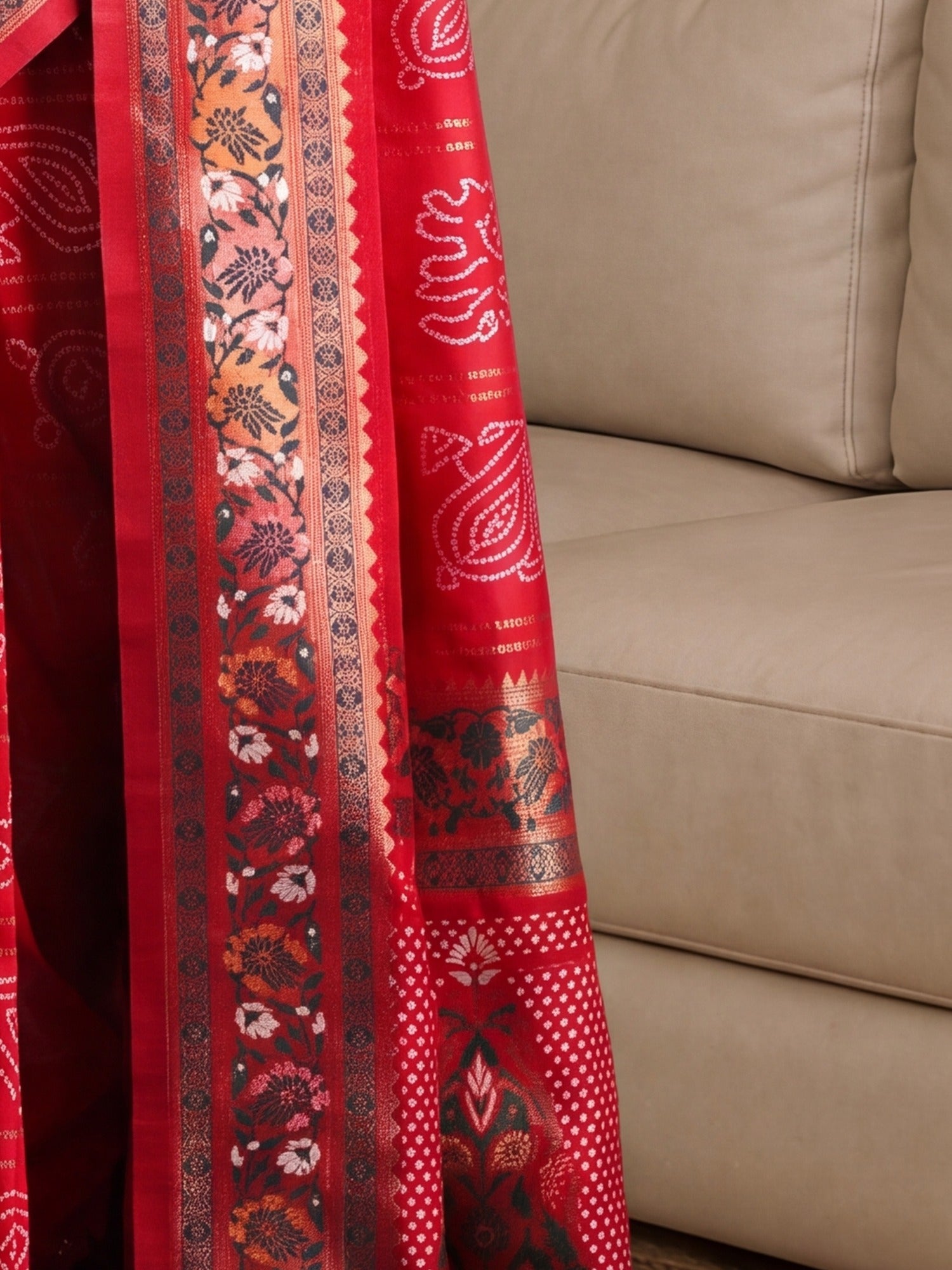 Pallu detail of red dola silk saree showing bandhani tie-dye dot work and zari border