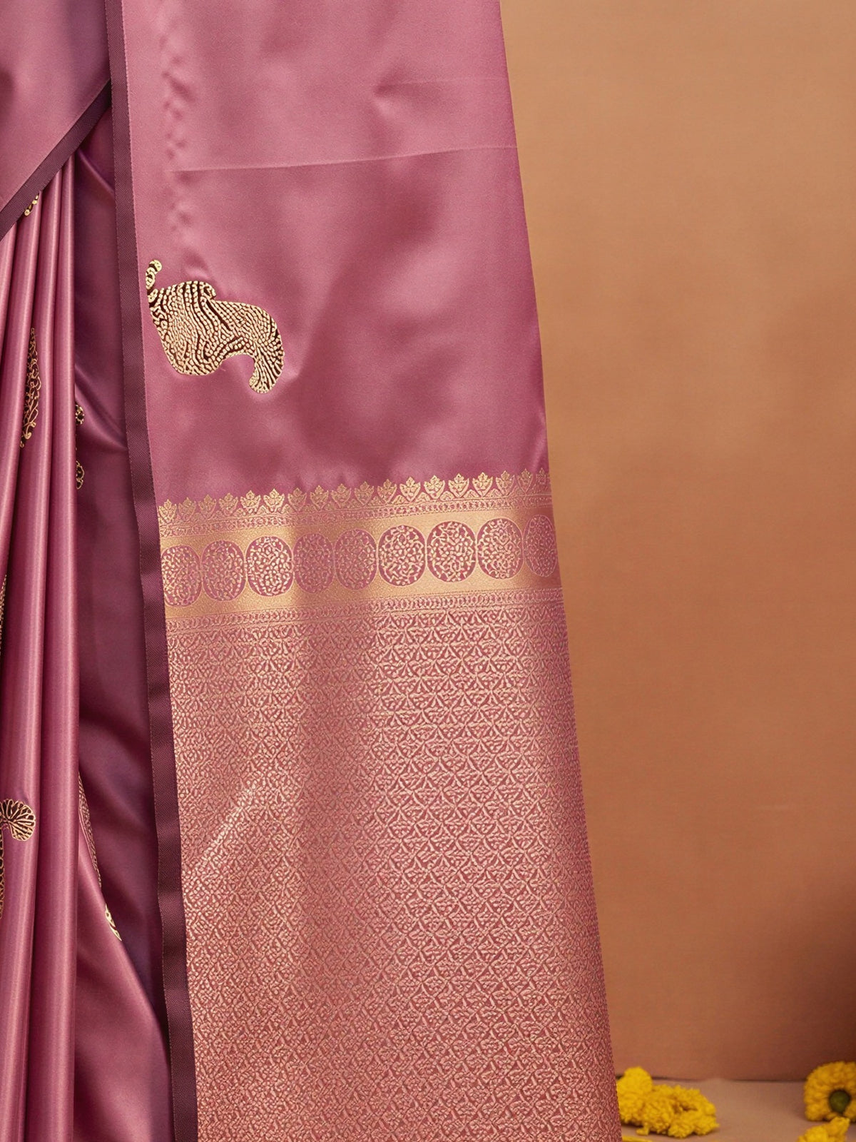 Pallu detail of mauve satin silk saree showing animal-print design and no border border