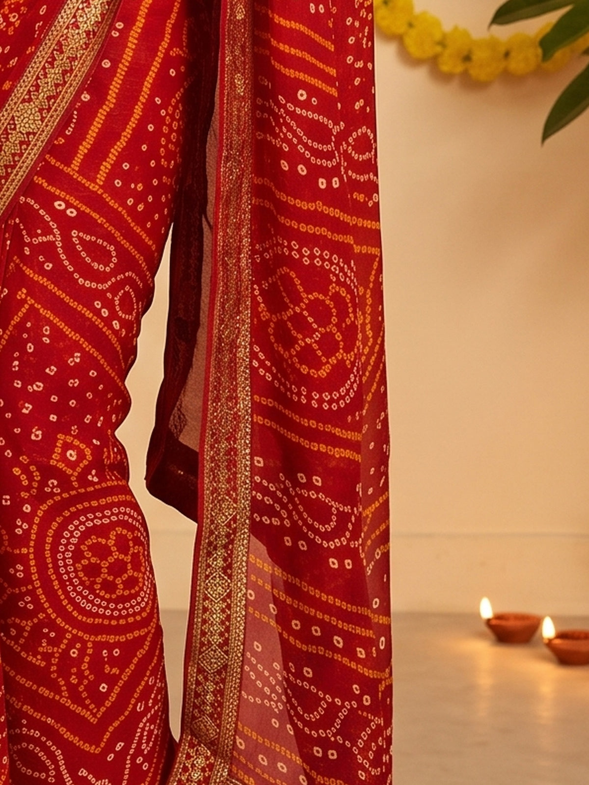 Pallu detail of red chiffon saree showing bandhani tie-dye dot work and embellished border