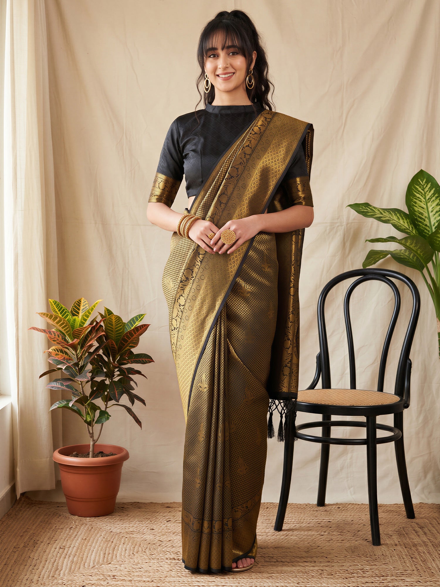 Woman wearing gold silk blend saree with woven motif design and black blouse