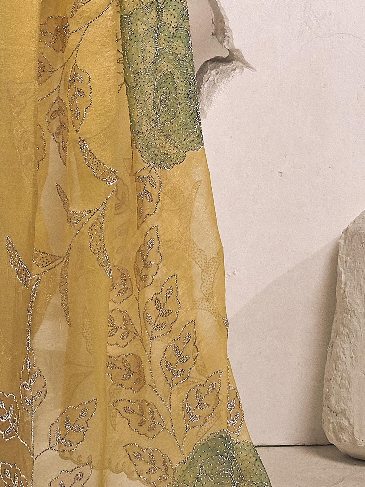 Pallu detail of yellow organza saree showing ornamented surface design and scallop border