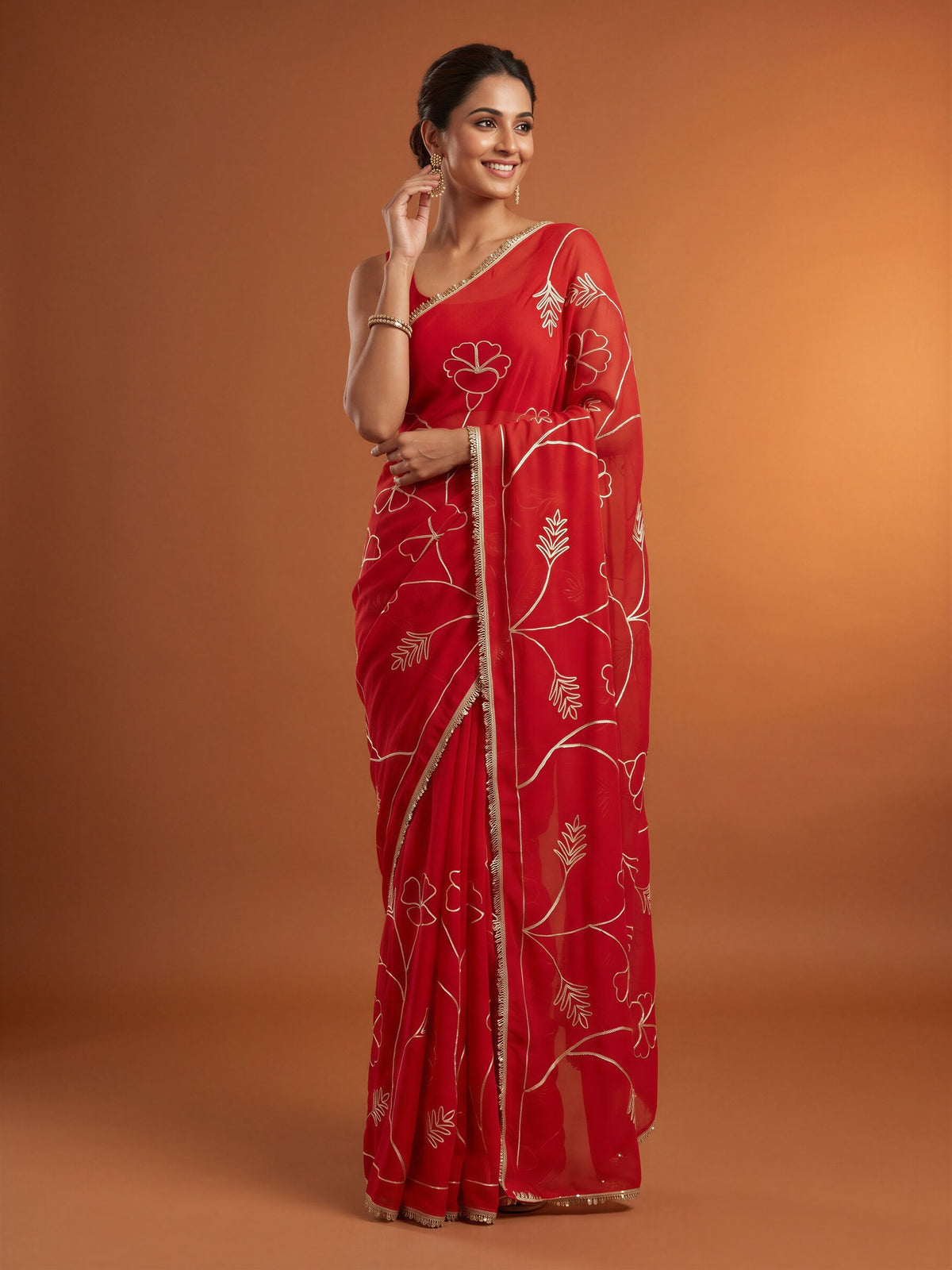 Woman wearing red georgette saree with embroidered motif work and red blouse