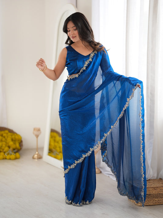 Woman wearing teal blue satin saree with clean solid-tone finish and teal blue blouse