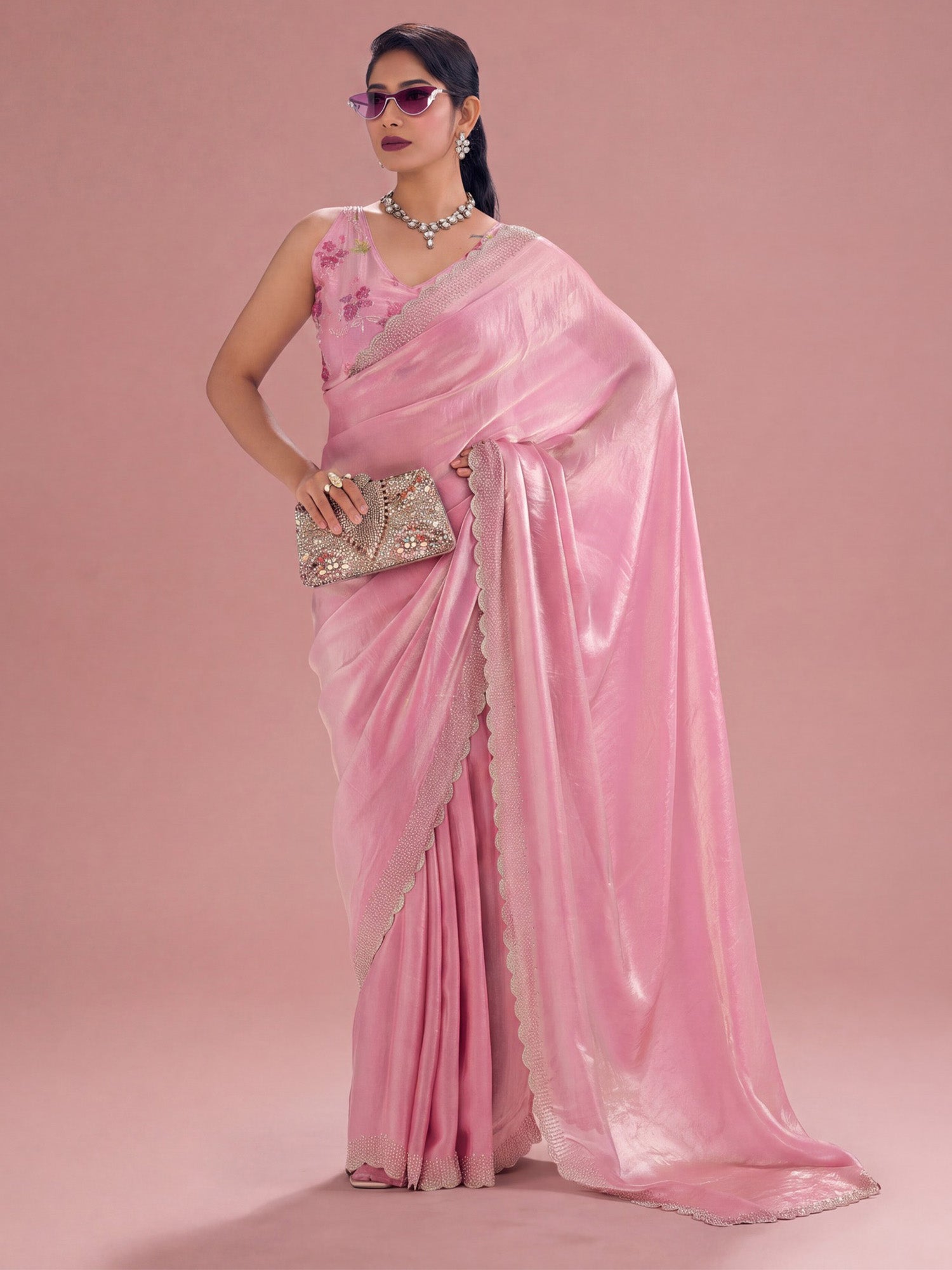 Woman wearing pink silk saree with ornamented surface design and pink blouse