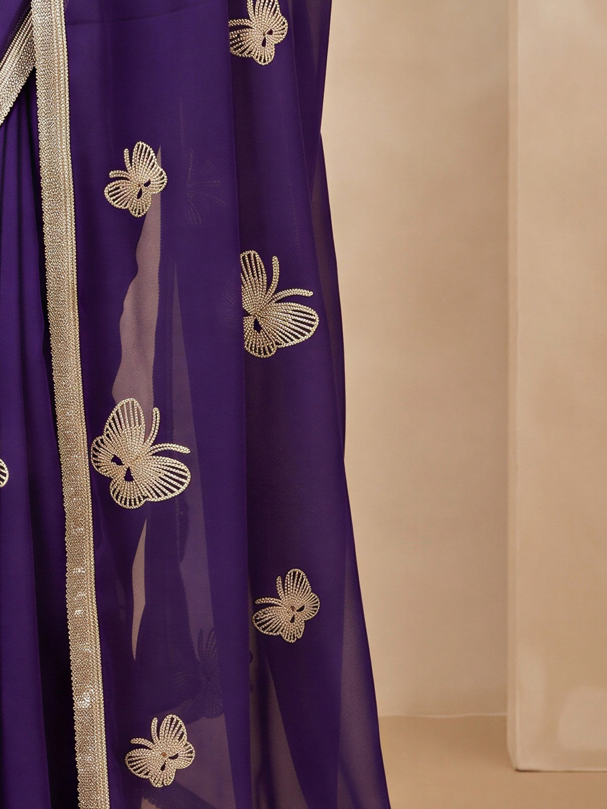 Pallu detail of purple georgette saree showing embroidered motif work and embellished border