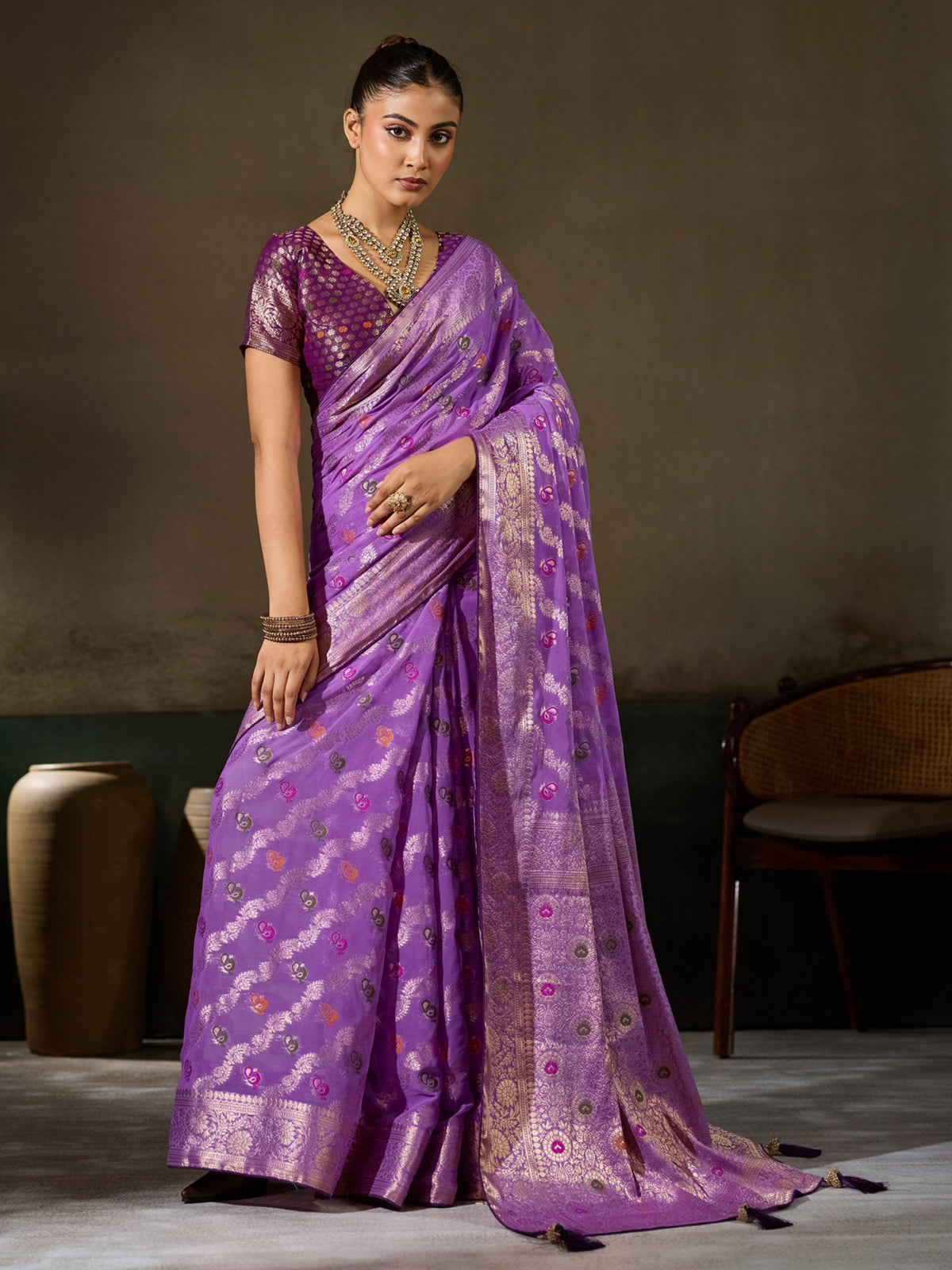 Woman wearing lavender georgette saree with woven motif design and wine blouse