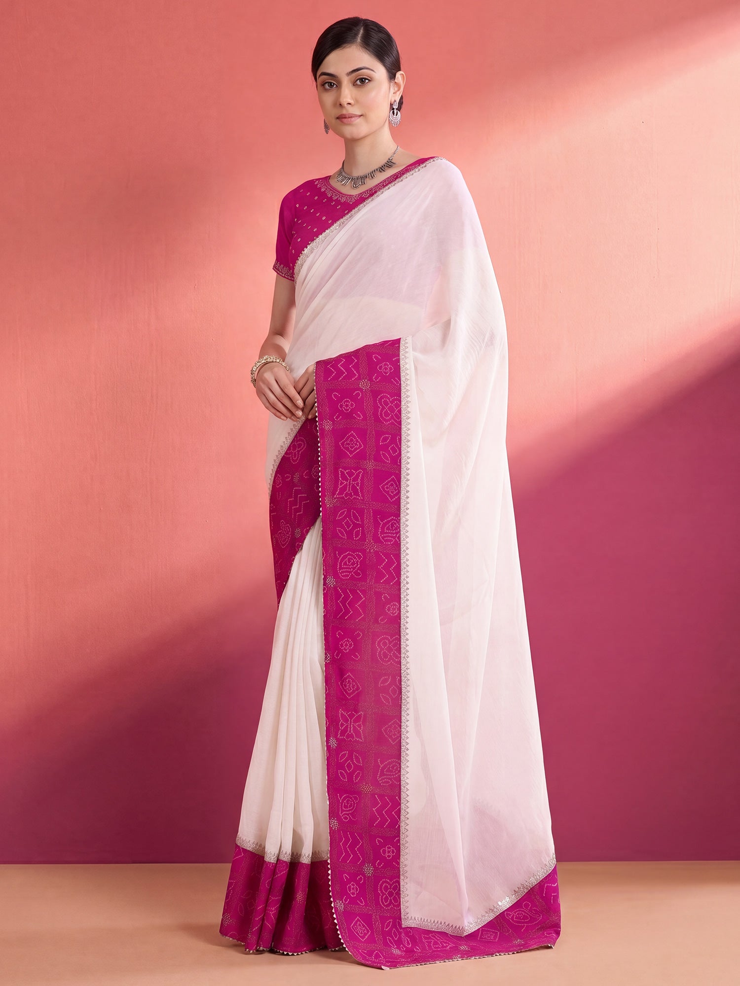 Woman wearing white vichitra silk saree with bandhani tie-dye dot work and pink blouse